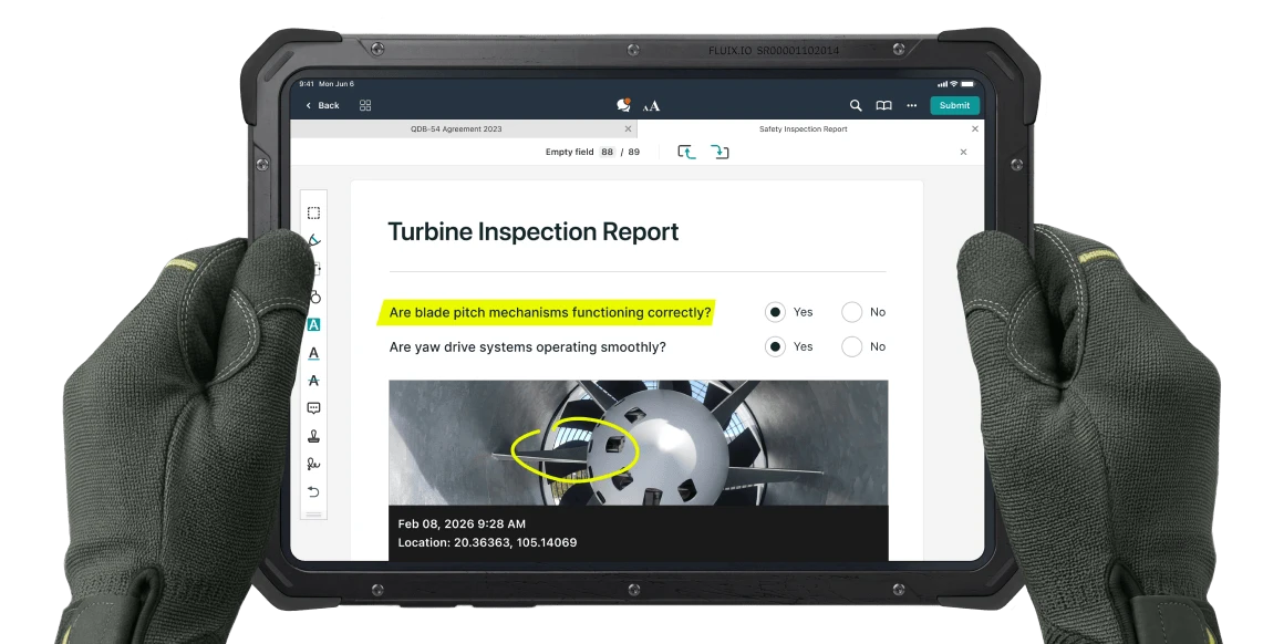 A tablet running the Fluix app, showing an open Turbine Inspection Report, held in work-gloved hands.